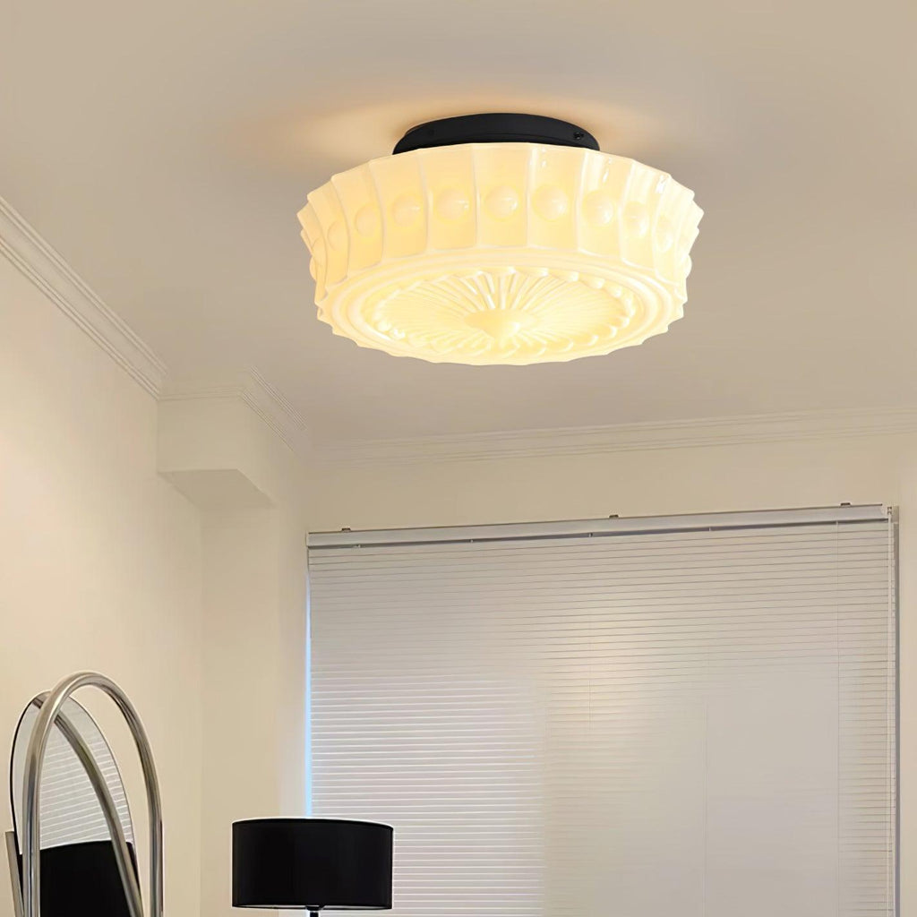 The white Clérachic fluted opal glass flush ceiling light lit above a hallway with a floor lamp and arched mirror.