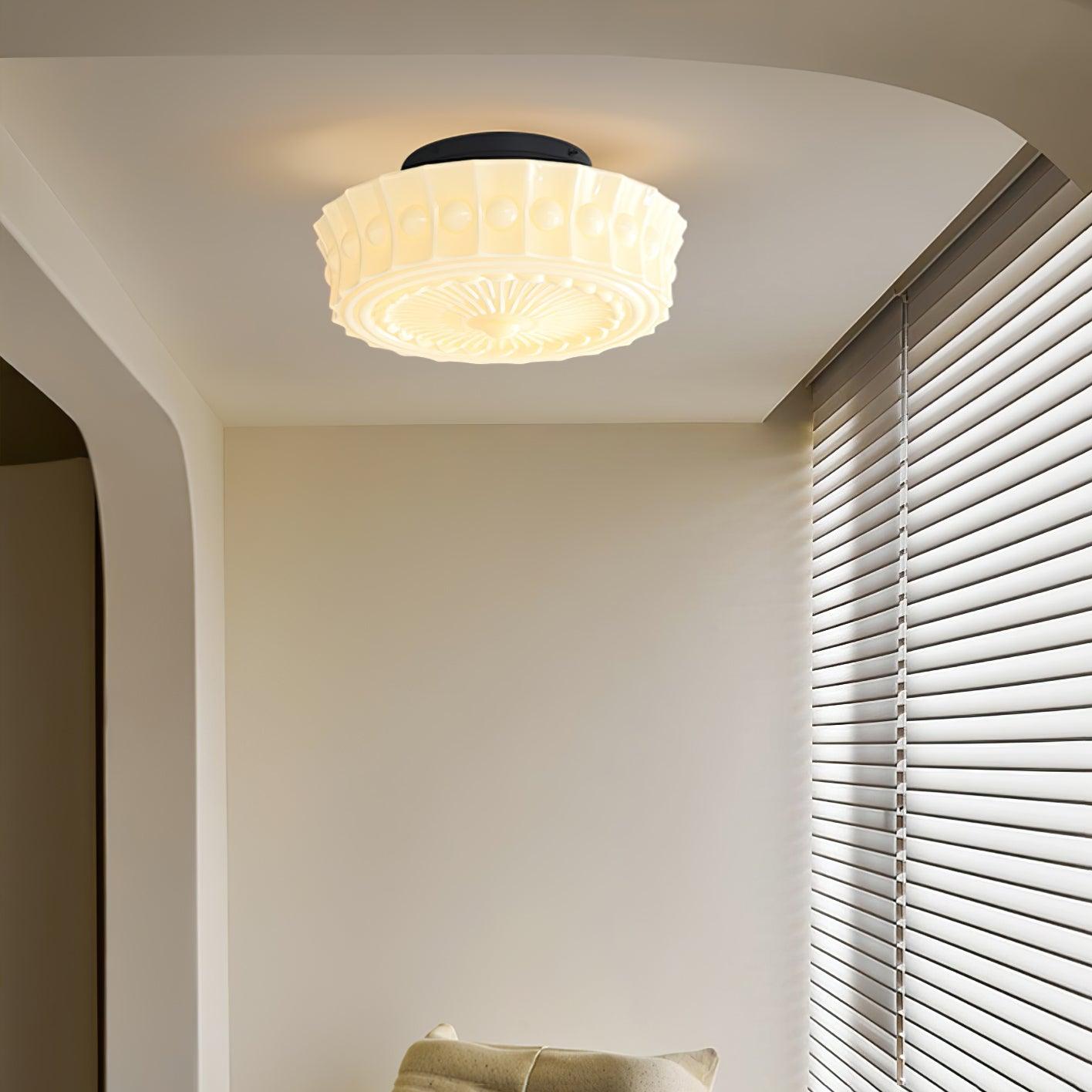 The beige Clérachic fluted opal glass flush ceiling light lit in an arched hallway leading to closet doors.