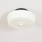 Close studio shot of the white Clérachic fluted opal glass flush ceiling light showing its raised boss detailing.
