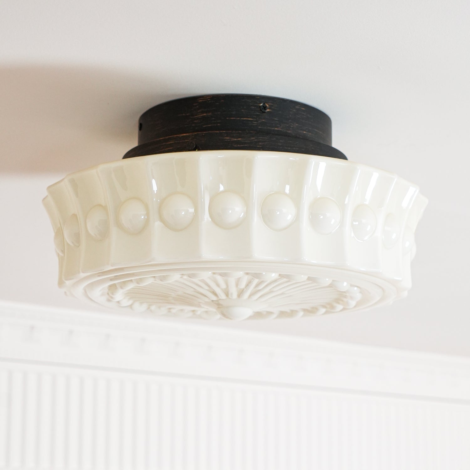 The white Clérachic fluted opal glass flush ceiling light shown unlit with its scalloped edge in sharp focus.