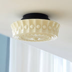 The beige Clérachic fluted opal glass flush ceiling light lit in a room with pale blue-toned window blinds.