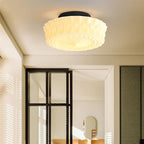 The white Clérachic fluted opal glass flush ceiling light lit above a room with a black-framed glass door.