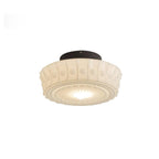 Straight-on studio shot of the white Clérachic fluted opal glass flush ceiling light switched on and glowing.