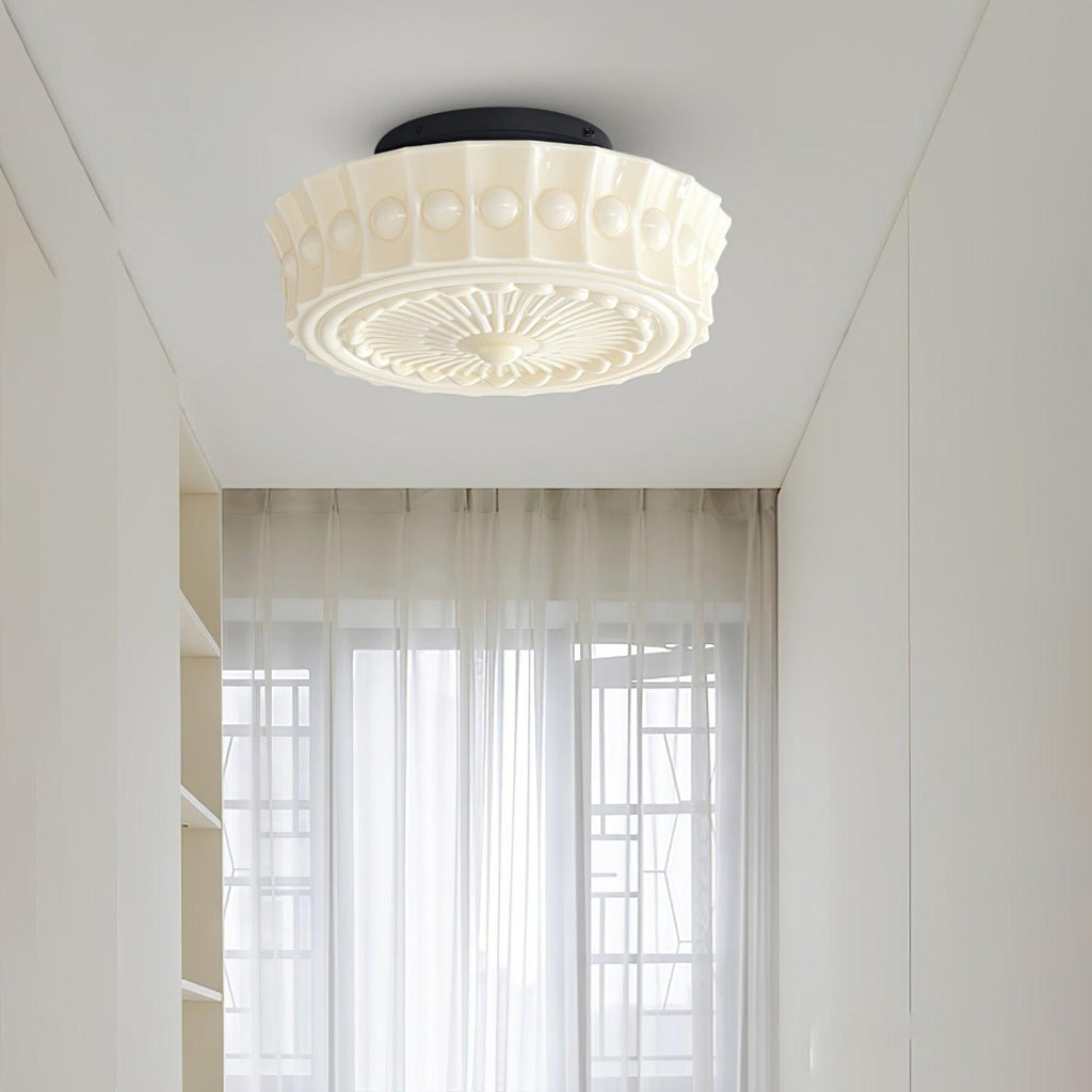 The beige Clérachic fluted opal glass flush ceiling light lit in a hallway with sheer curtains nearby.