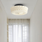 The beige Clérachic fluted opal glass flush ceiling light lit in a hallway with sheer curtains nearby.
