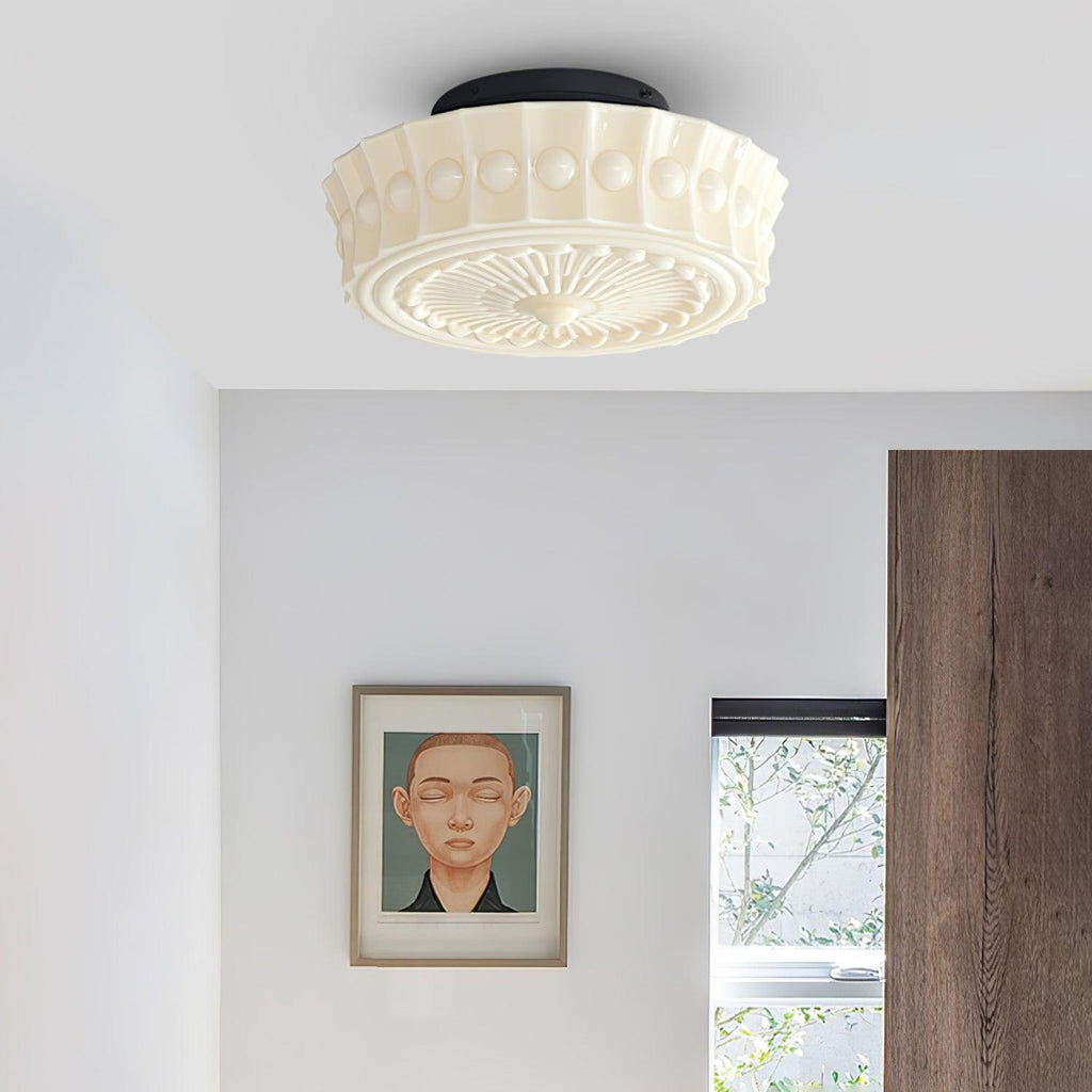Another angle of the white Clérachic fluted opal glass flush ceiling light lit beside a framed bedroom portrait.