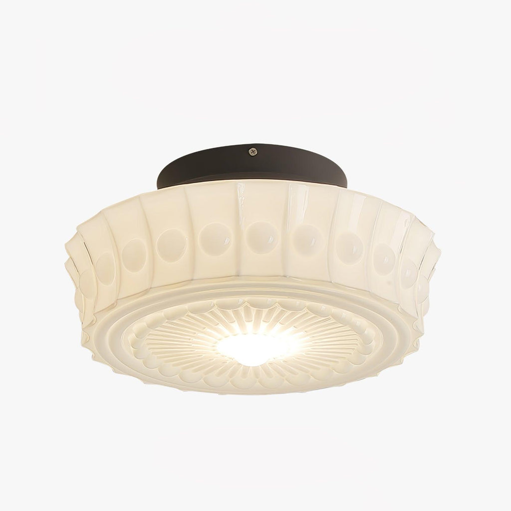 The white Clérachic fluted opal glass flush ceiling light lit on a plain backdrop, glass glowing from within.