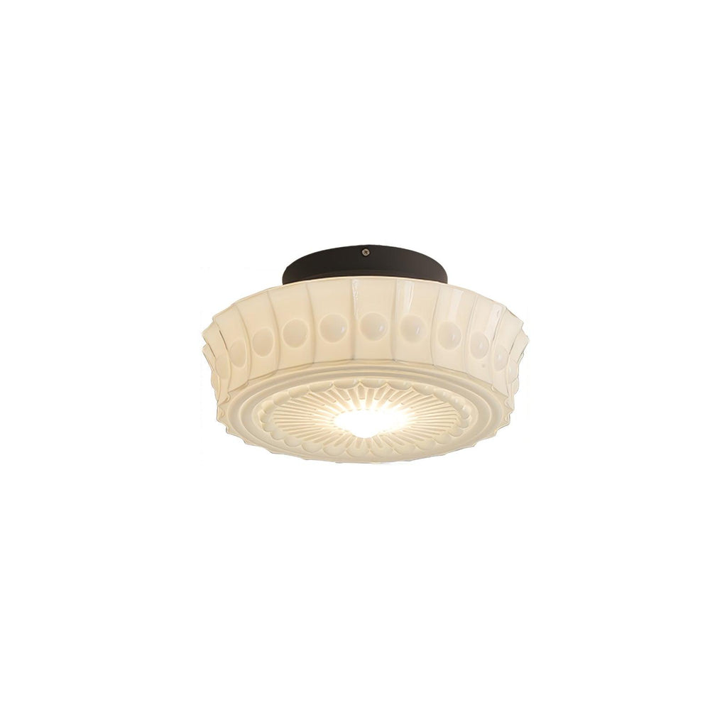 A further studio angle of the lit white Clérachic fluted opal glass flush ceiling light against a plain backdrop.