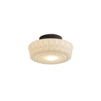A further studio angle of the lit white Clérachic fluted opal glass flush ceiling light against a plain backdrop.