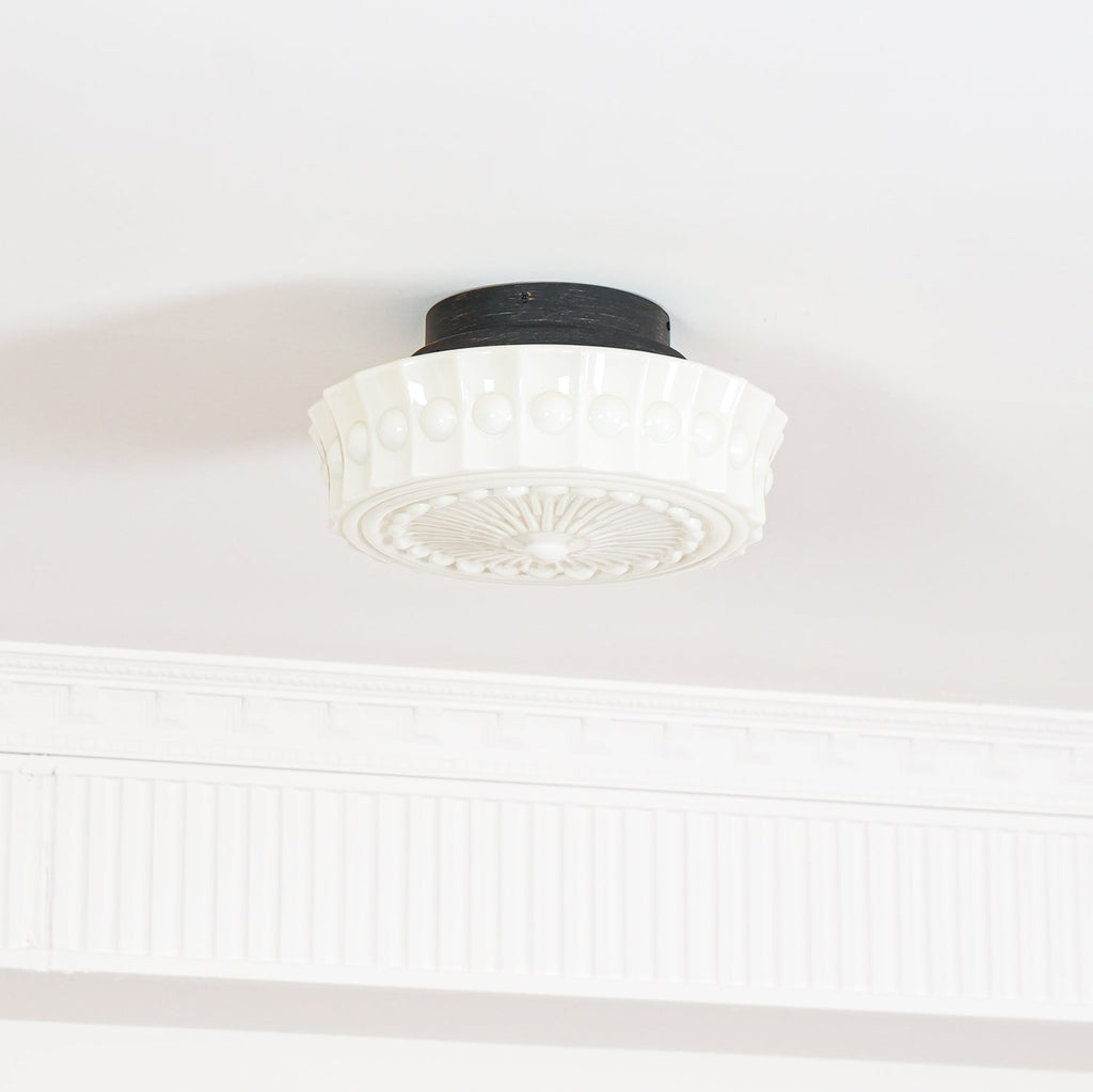 Close studio detail of the unlit white Clérachic fluted opal glass flush ceiling light and its raised bosses.