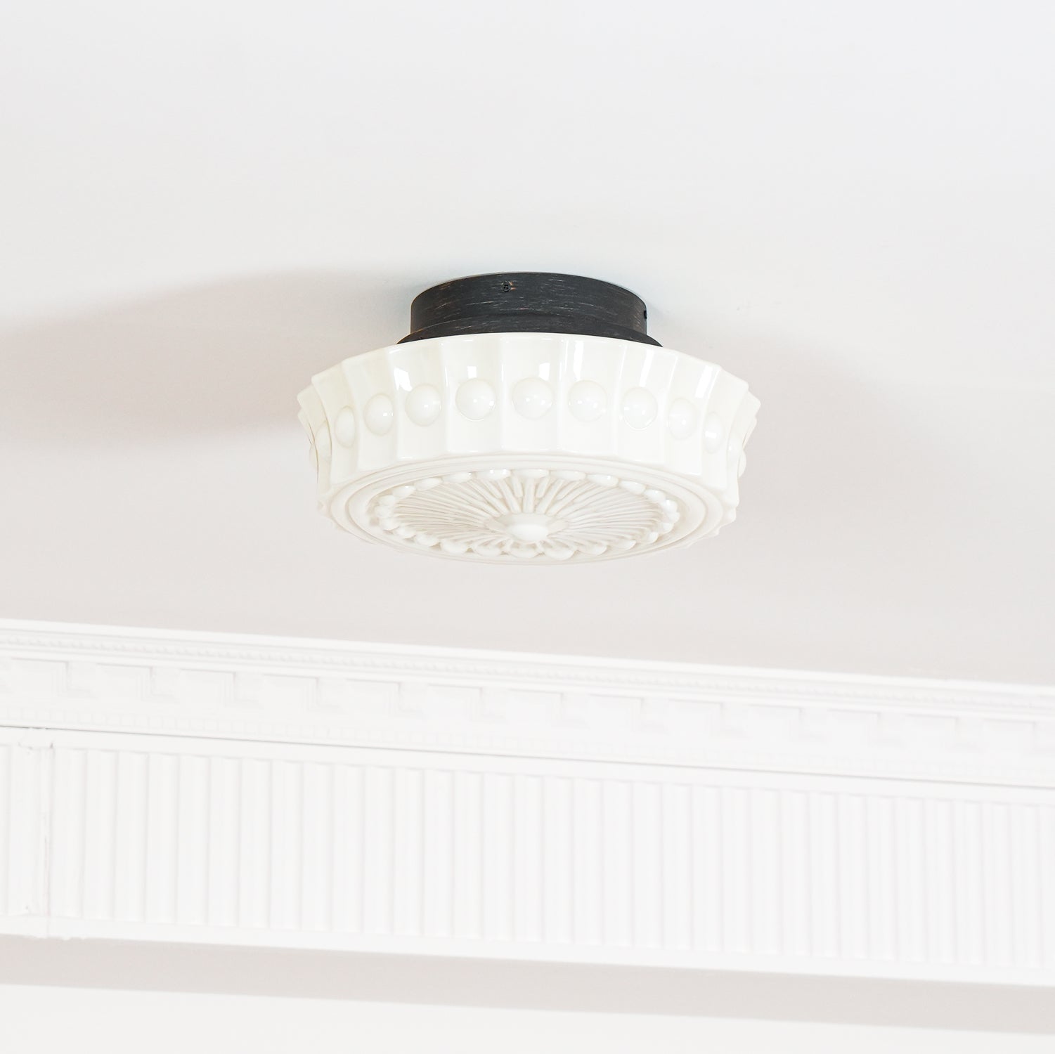 Close studio detail of the unlit white Clérachic fluted opal glass flush ceiling light and its raised bosses.