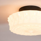 A cropped close-up of the lit white Clérachic fluted opal glass flush ceiling light showing its fluted glass.