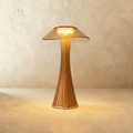 Clérachic bronze mushroom-shaped table lamp, 27.4 cm tall, with a fluted stem and tinted shade glowing warm white
