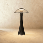 Clérachic black fluted table lamp with a clear wide-brimmed shade, lit warm white against a plaster wall