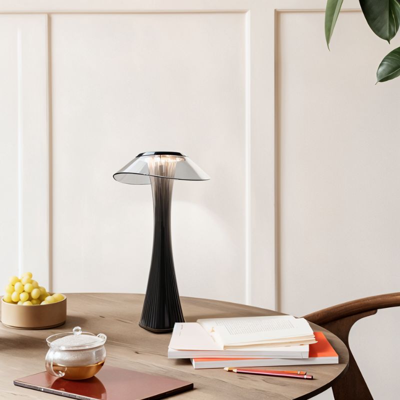Clérachic black fluted table lamp with a clear shade on a round wooden table beside books and a glass teapot