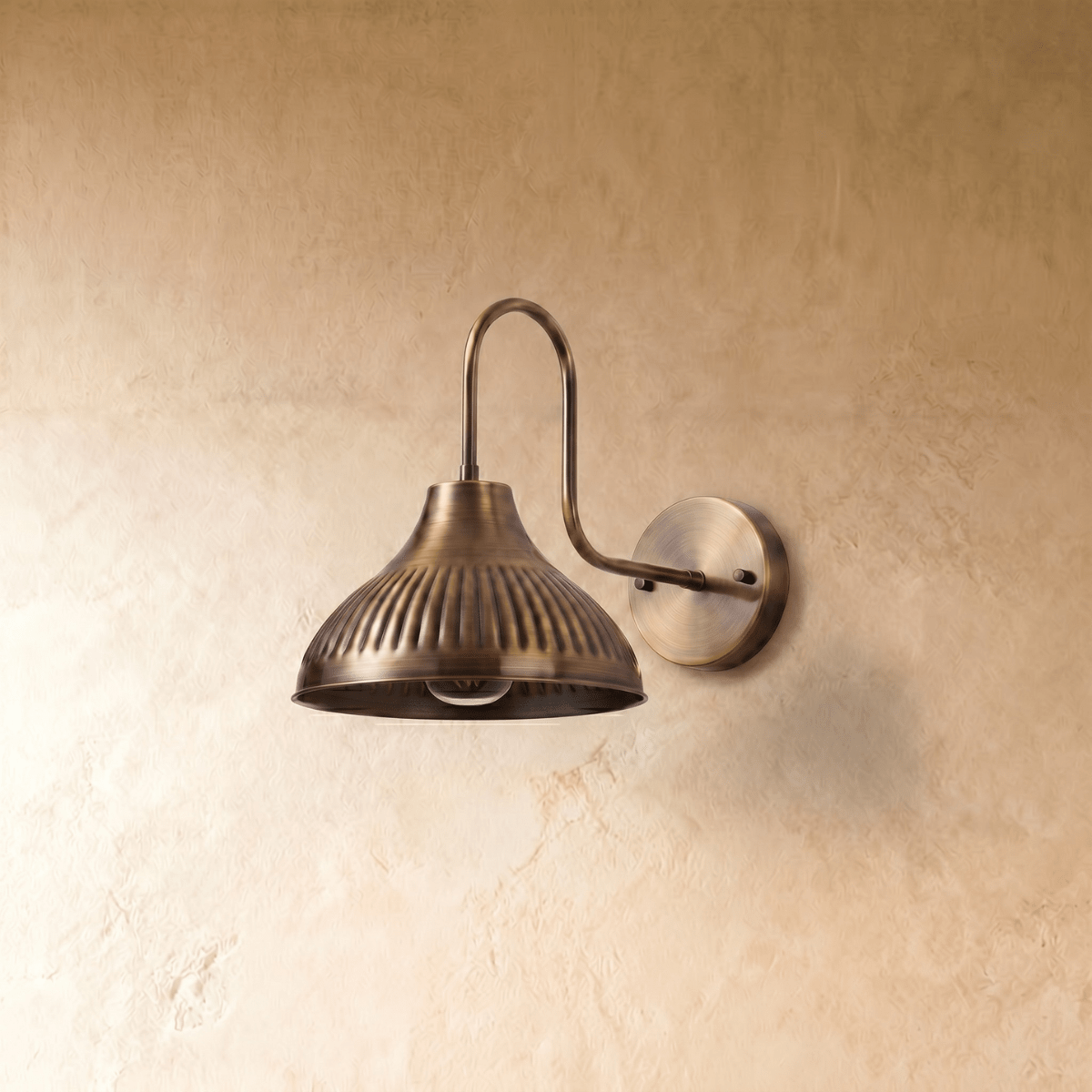 This vintage brass Clérachic wall lamp is shown from another angle, its ribbed shade glowing warmly.