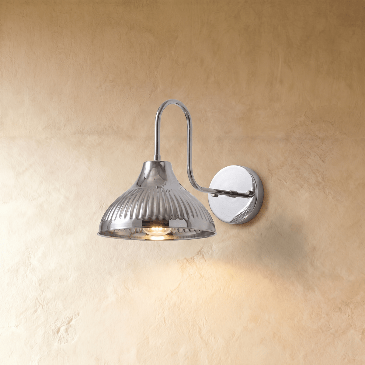 Clérachic wall lamp in chrome, its fluted dome shade curving down from a polished gooseneck arm.
