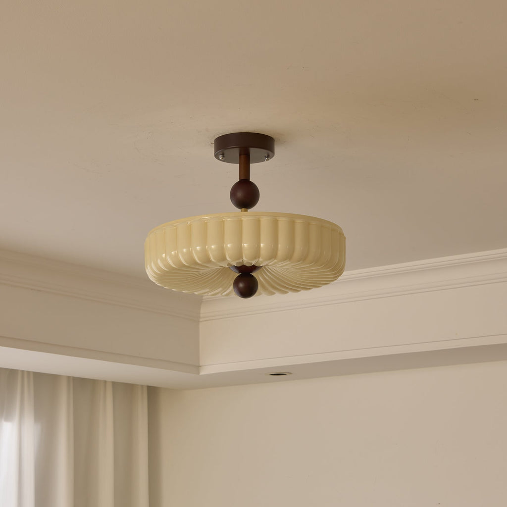 Unlit ribbed disc shade with radiating folds underneath, this Clérachic ceiling light hangs close to a white cornice.