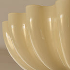 Close view of the glossy cream ridges along the lower edge of the scalloped shade on this Clérachic ceiling light.