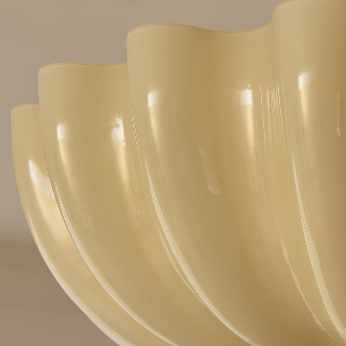 Close view of the glossy cream ridges along the lower edge of the scalloped shade on this Clérachic ceiling light.