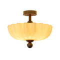 Lit scalloped cream shade with a walnut canopy and ball finial, this Clérachic ceiling light shown on a white background.