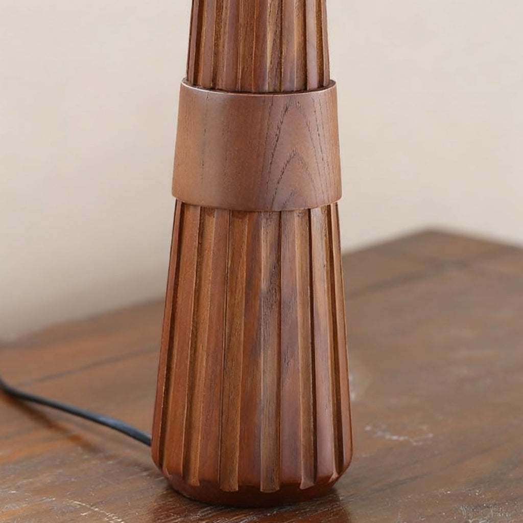 Close view of the fluted walnut base and the wide wood band on this Clérachic table lamp, with its black cord at the left.