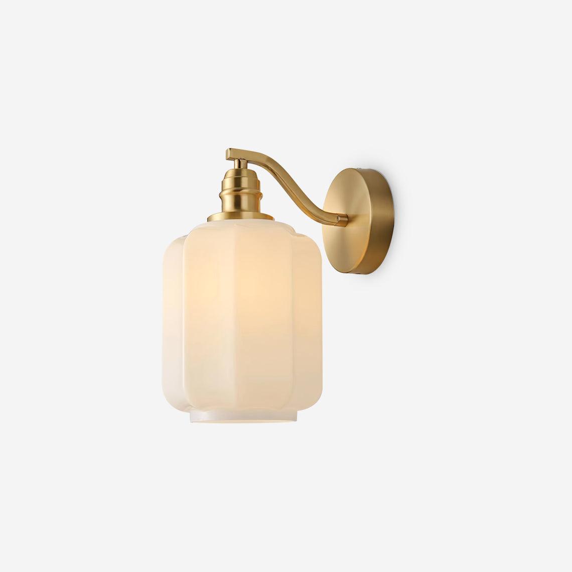 The Clérachic Fluted White Glass Wall Sconce on a plain white background, brass arm and glowing fluted shade seen from the side.