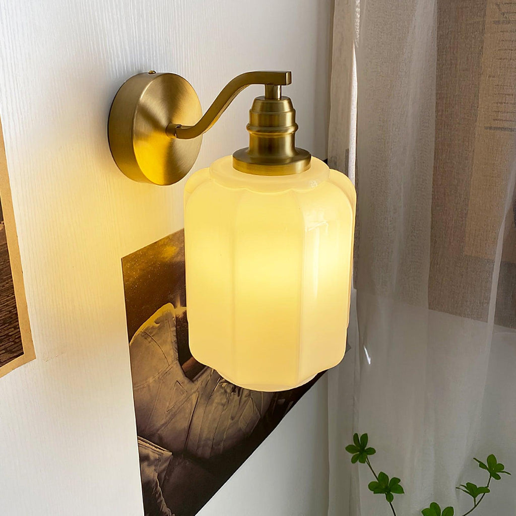 Clérachic Fluted White Glass Wall Sconce switched on beside a framed print, warm light washing the wall and the sheer curtain.