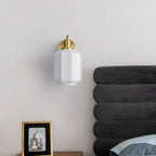 Unlit Clérachic Fluted White Glass Wall Sconce beside a charcoal channelled headboard, its gloss white shade catching daylight.