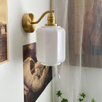 Clérachic Fluted White Glass Wall Sconce seen close in a corner, the thick white glass glossy against a sheer curtain.