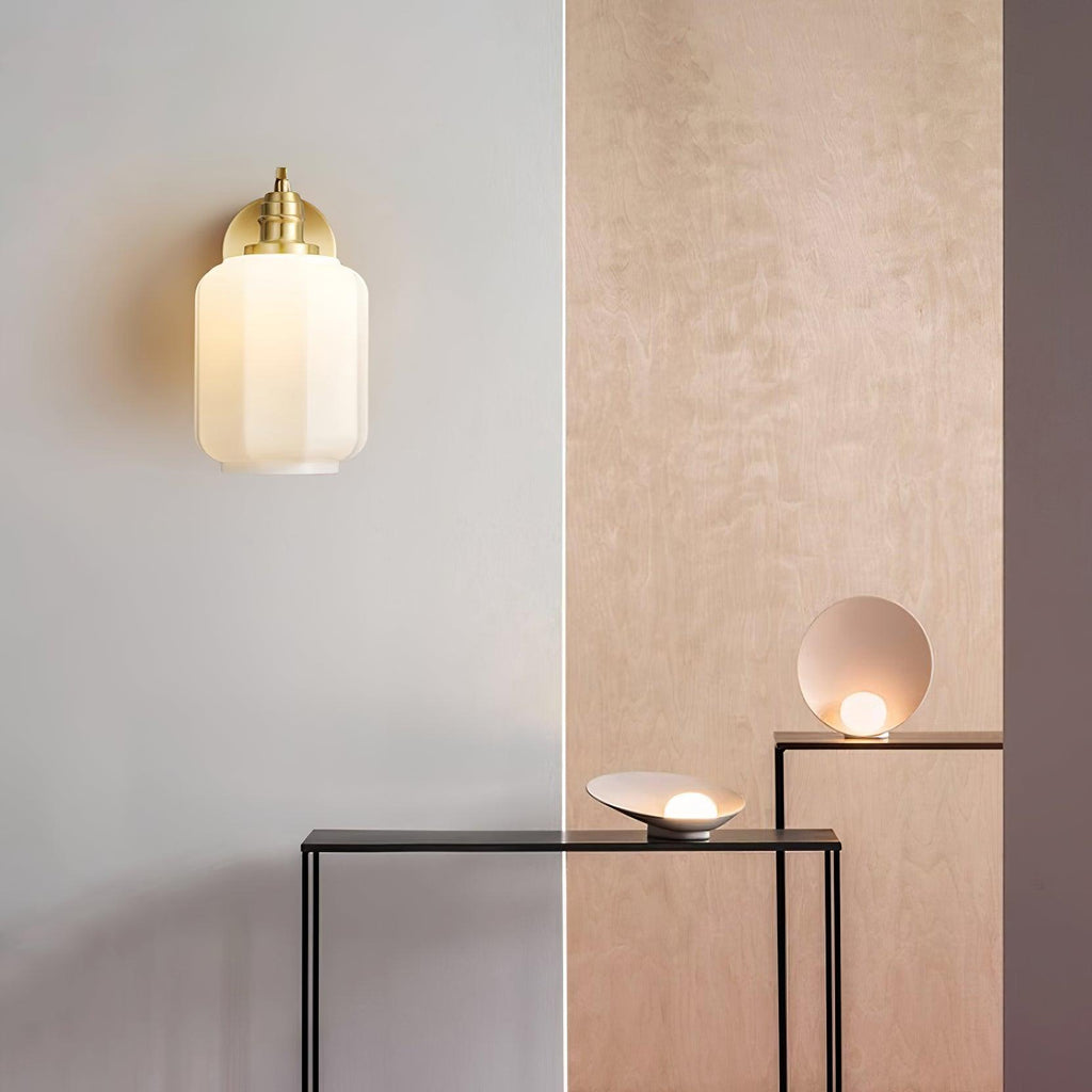 Clérachic Fluted White Glass Wall Sconce lit on a pale wall beside birch panelling and two console tables with small lamps.
