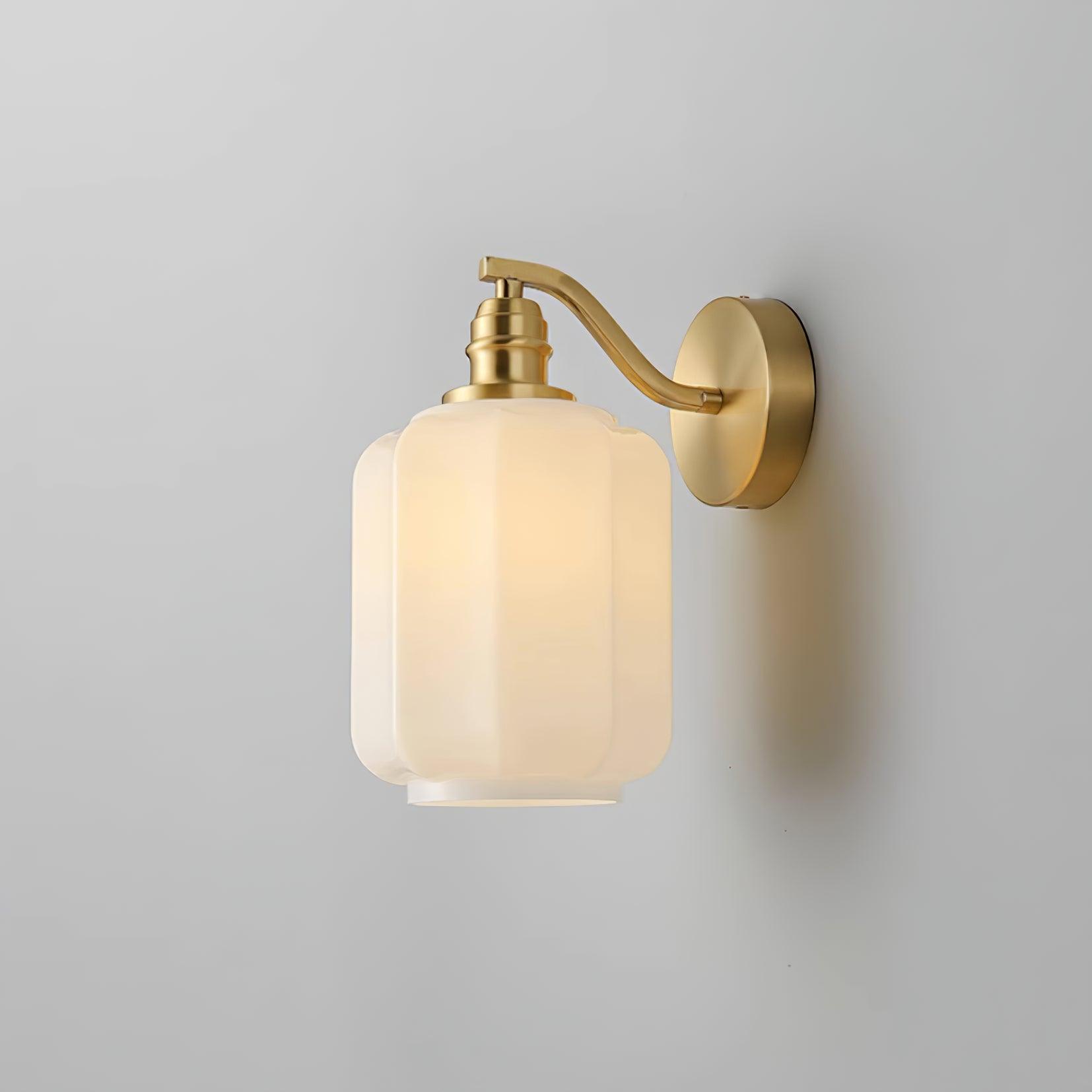 Angled studio view of the lit Clérachic Fluted White Glass Wall Sconce, brass hardware sharing one satin finish throughout.
