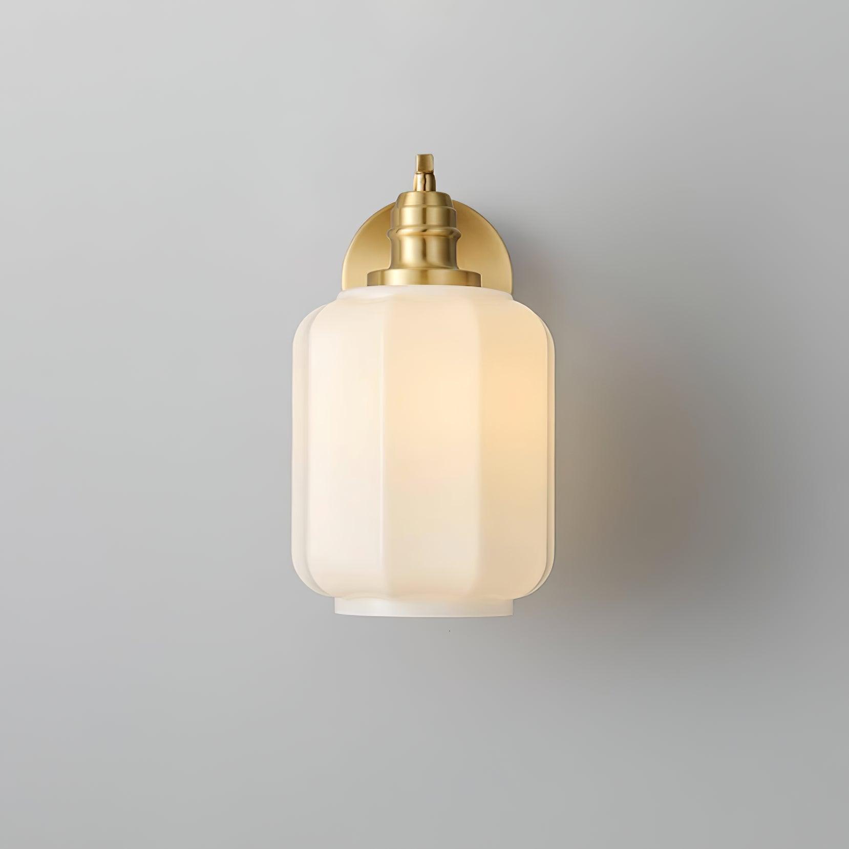 Front view of the lit Clérachic Fluted White Glass Wall Sconce, the fluted shade centred with only the brass collar showing.