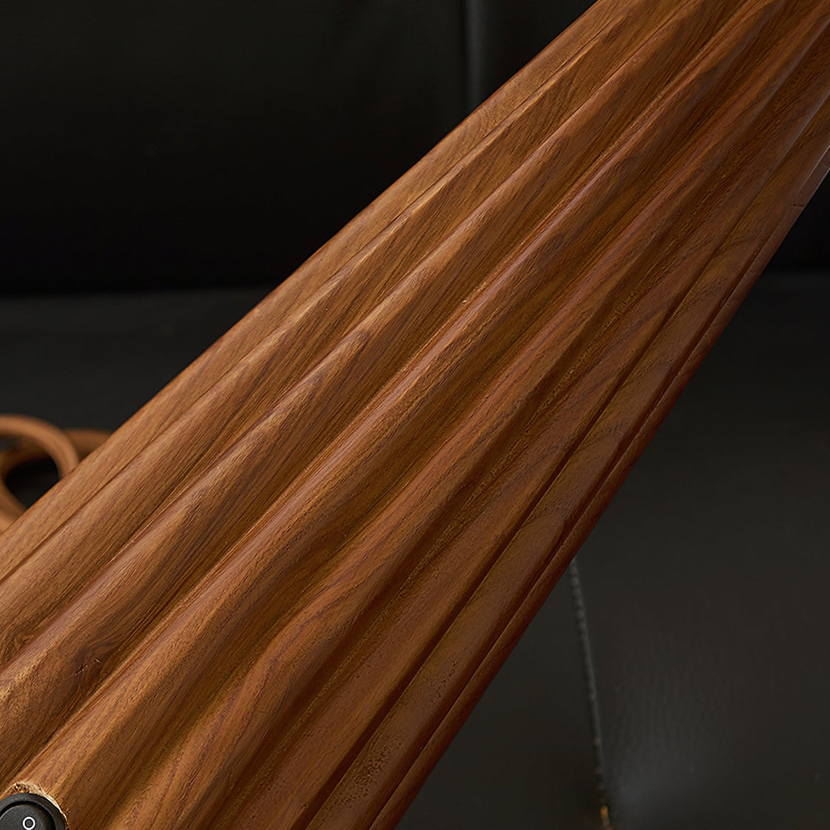 Close view of the grained, fluted wooden base of this Clérachic table lamp, with the switch near the foot.