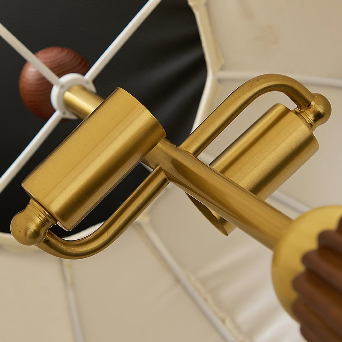 Close view of the brass lamp-holder fittings and wooden finial inside the shade of this Clérachic table lamp.