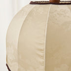 Close view of the woven cream fabric with a faint floral pattern and dark braid trim on this Clérachic lamp shade.