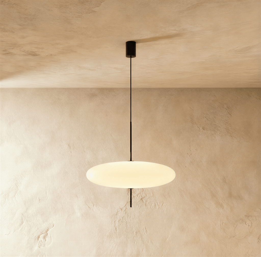 Clérachic all-white saucer pendant with a smooth glowing acrylic diffuser on a thin black rod from a black ceiling canopy.