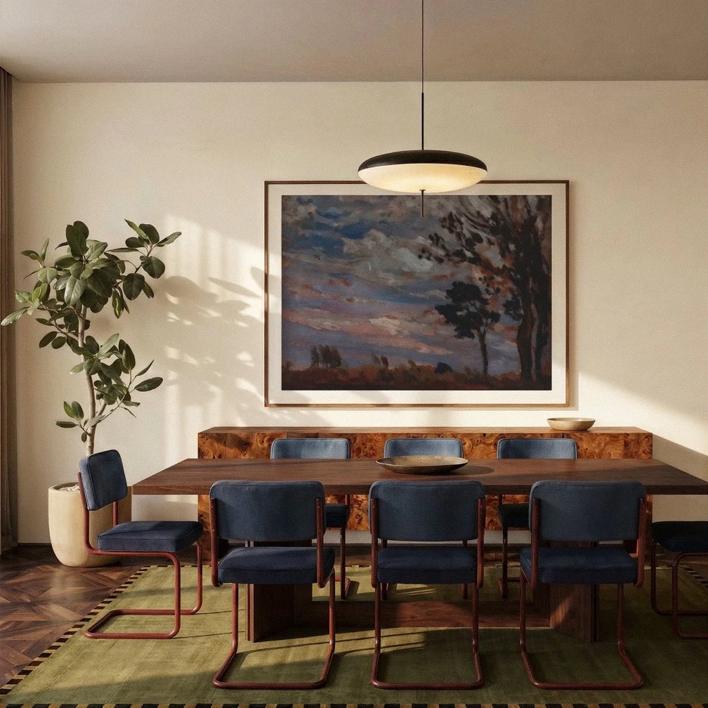 Clérachic black and white saucer pendant hung above a long walnut dining table, with blue velvet chairs and a large landscape painting.