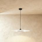 Clérachic wide frosted disc pendant with a black cone cap and round dark centre, hanging from a black canopy and cord.