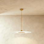 Clérachic frosted disc pendant with polished gold fittings and a slim stem, hanging below a round gold canopy.