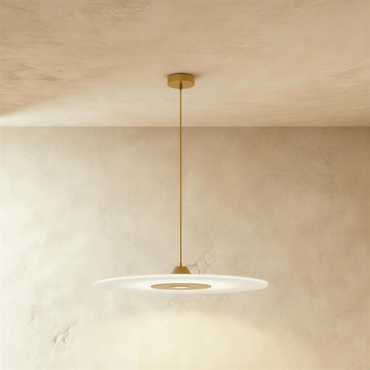 Clérachic broad frosted disc pendant in gold, its brass-toned centre panel glowing under a plaster ceiling.