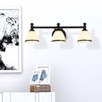 The three-light Clérachic frosted bell vanity light glows above a console styled with a framed black-ink botanical print.