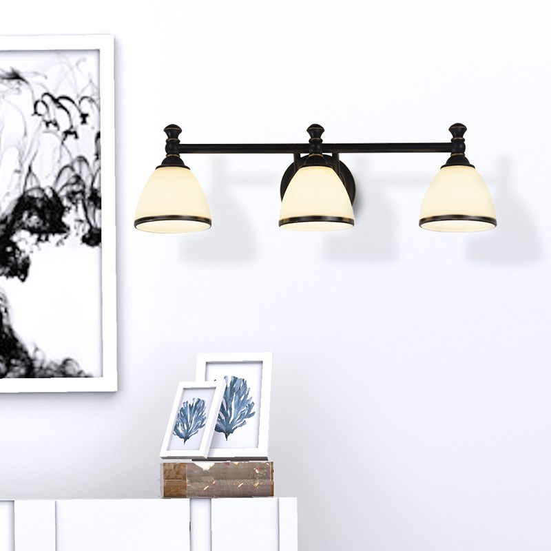 The three-light Clérachic frosted bell vanity light glows above a console styled with a framed black-ink botanical print.