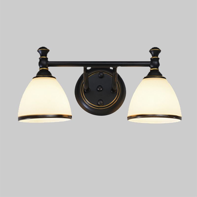 The two-light Clérachic frosted bell vanity light against a neutral gray backdrop, both opal bell shades lit from within.
