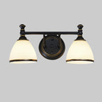 The two-light Clérachic frosted bell vanity light against a neutral gray backdrop, both opal bell shades lit from within.