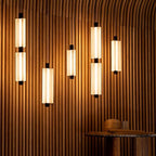 A cluster of frosted white Clérachic pendants, one and two heads tall, glows against a curved wall of ribbed timber.