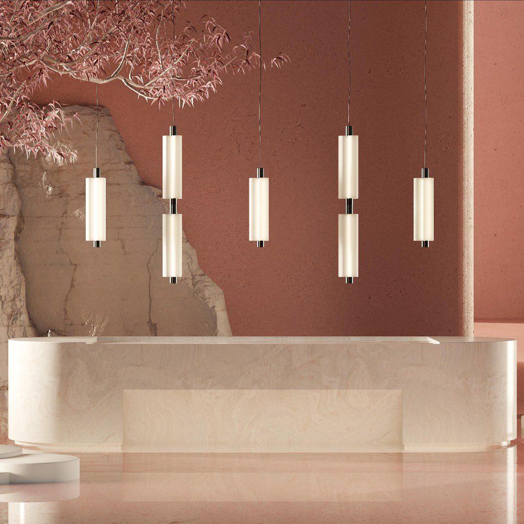 Five Clérachic pendants of different heights hang at a terracotta-pink reception desk with a pale stone front.