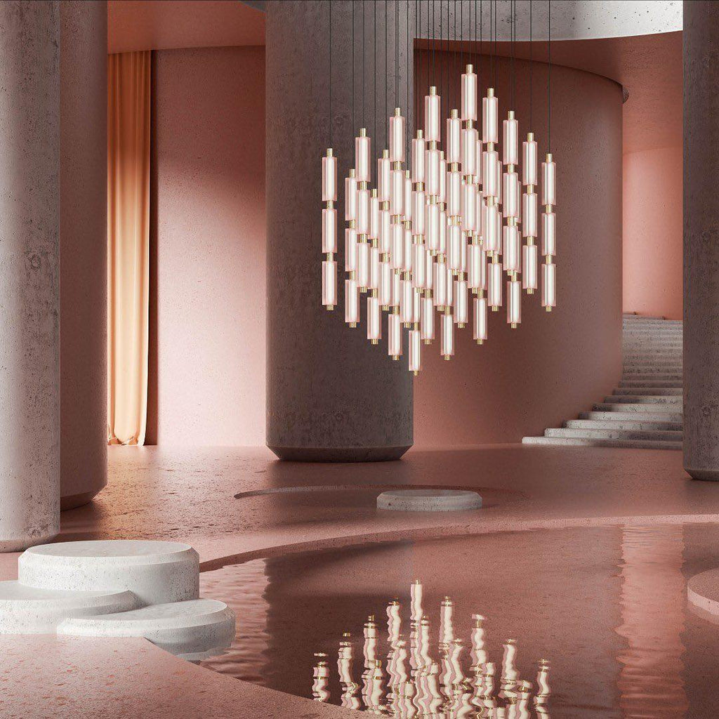 A large cluster of tiny frosted Clérachic pendants hangs in a pink stone atrium, reflected in the water below.