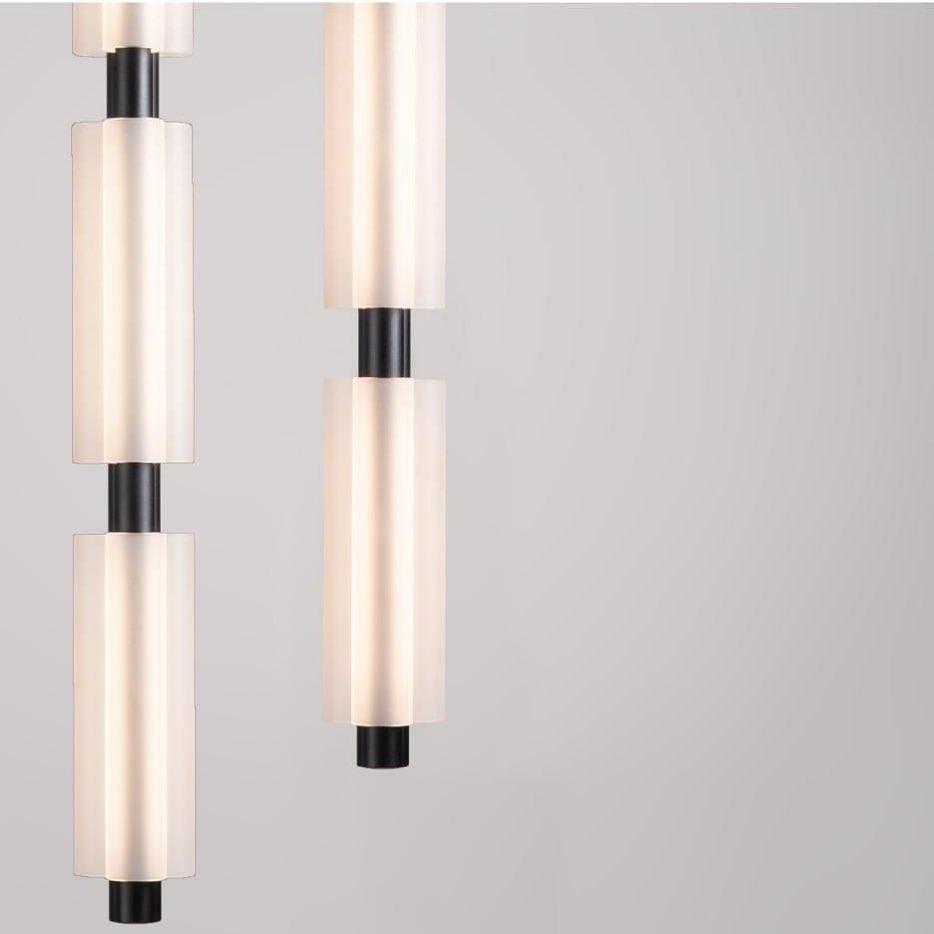 Close view of two black-fitted Clérachic pendants, the frosted white cylinders glowing against a pale grey backdrop.
