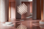 Hundreds of tiny frosted Clérachic pendants form a diamond-shaped cluster between stone columns, with a pink pool below.